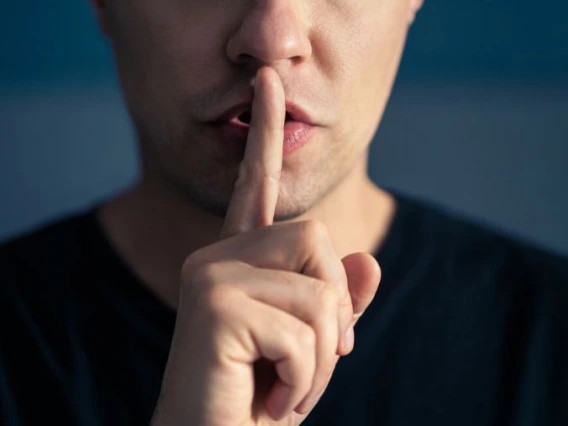 Person with their finger to their lips, making a "shhhhh" sound.